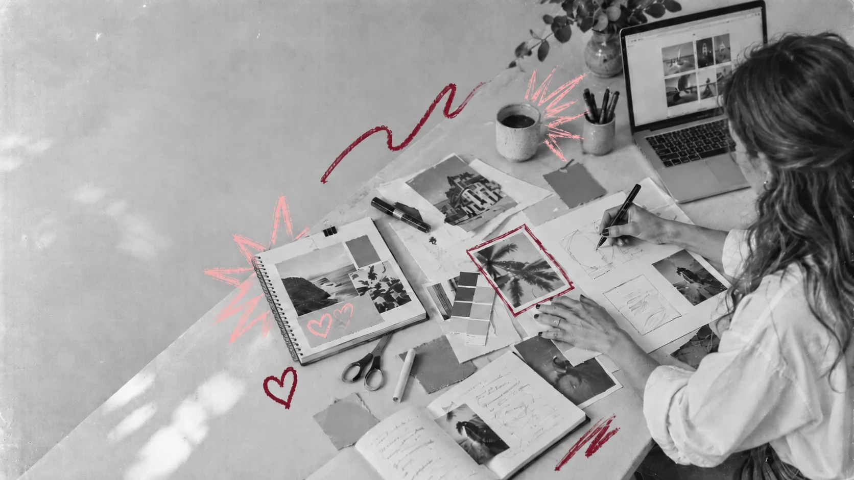 Kreativer Arbeitsplatz mit Moodboards und dunkelroten und rosa Zeichnungen